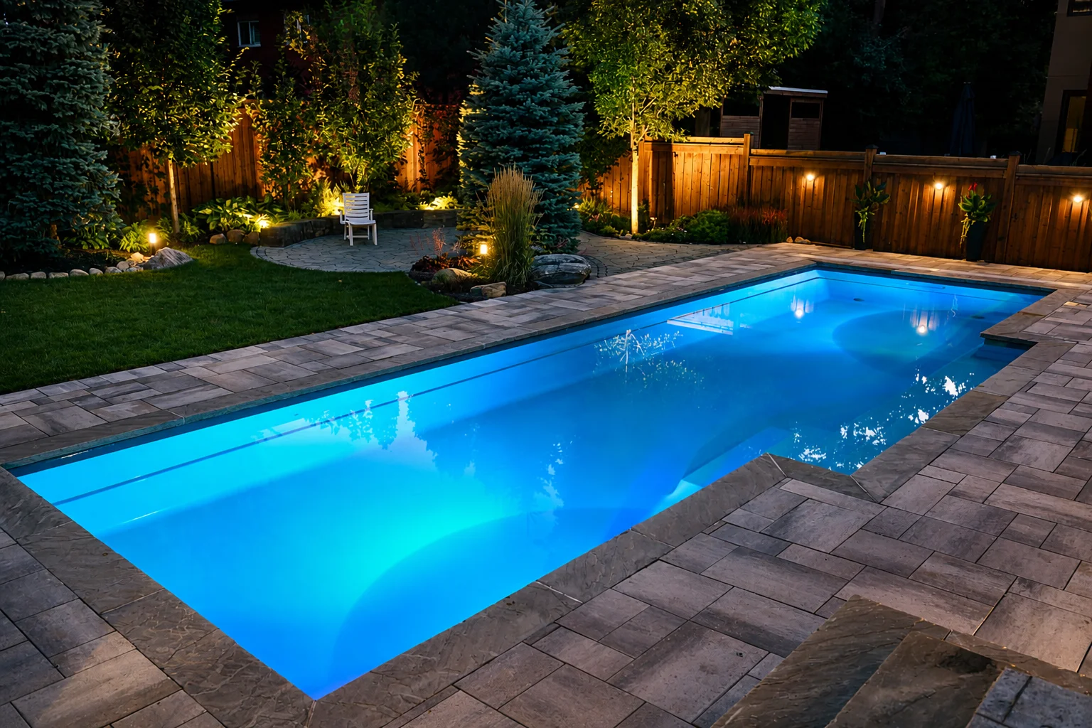 illuminated backyard swimming pool at night